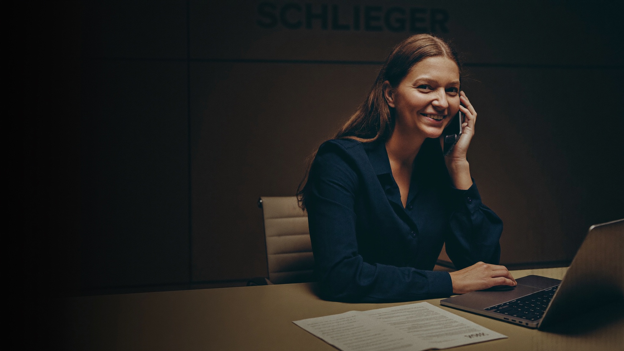Specialistka pohledávek telefonuje v pražské kanceláři Schlieger